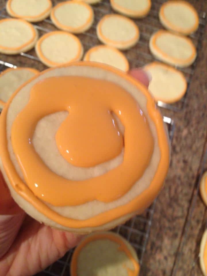 sugar cookie has some orange icing painted on ut