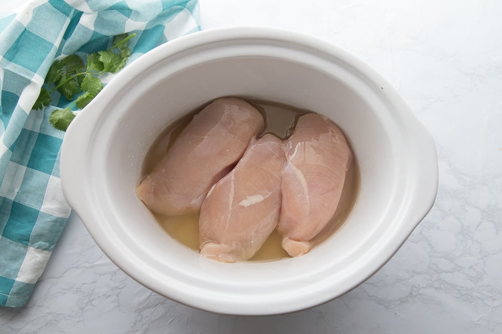 chicken breasts in a crock pot with chicken broth