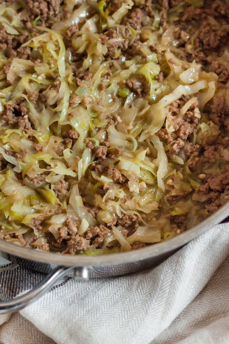 wilted cabbage, ground beef and onions in a skillet