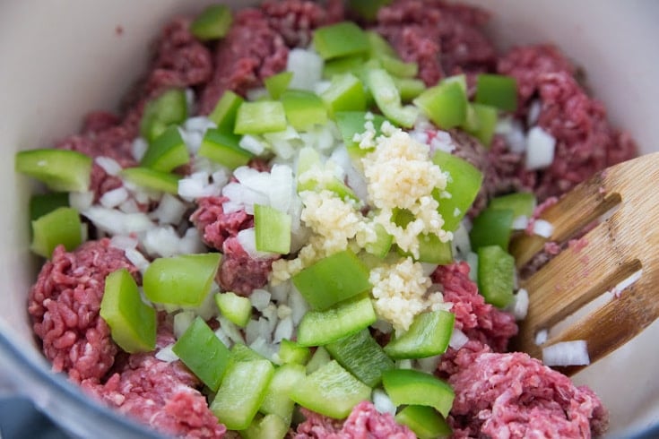 ground beef, onions, green peppers, and garlic in a pot to saute