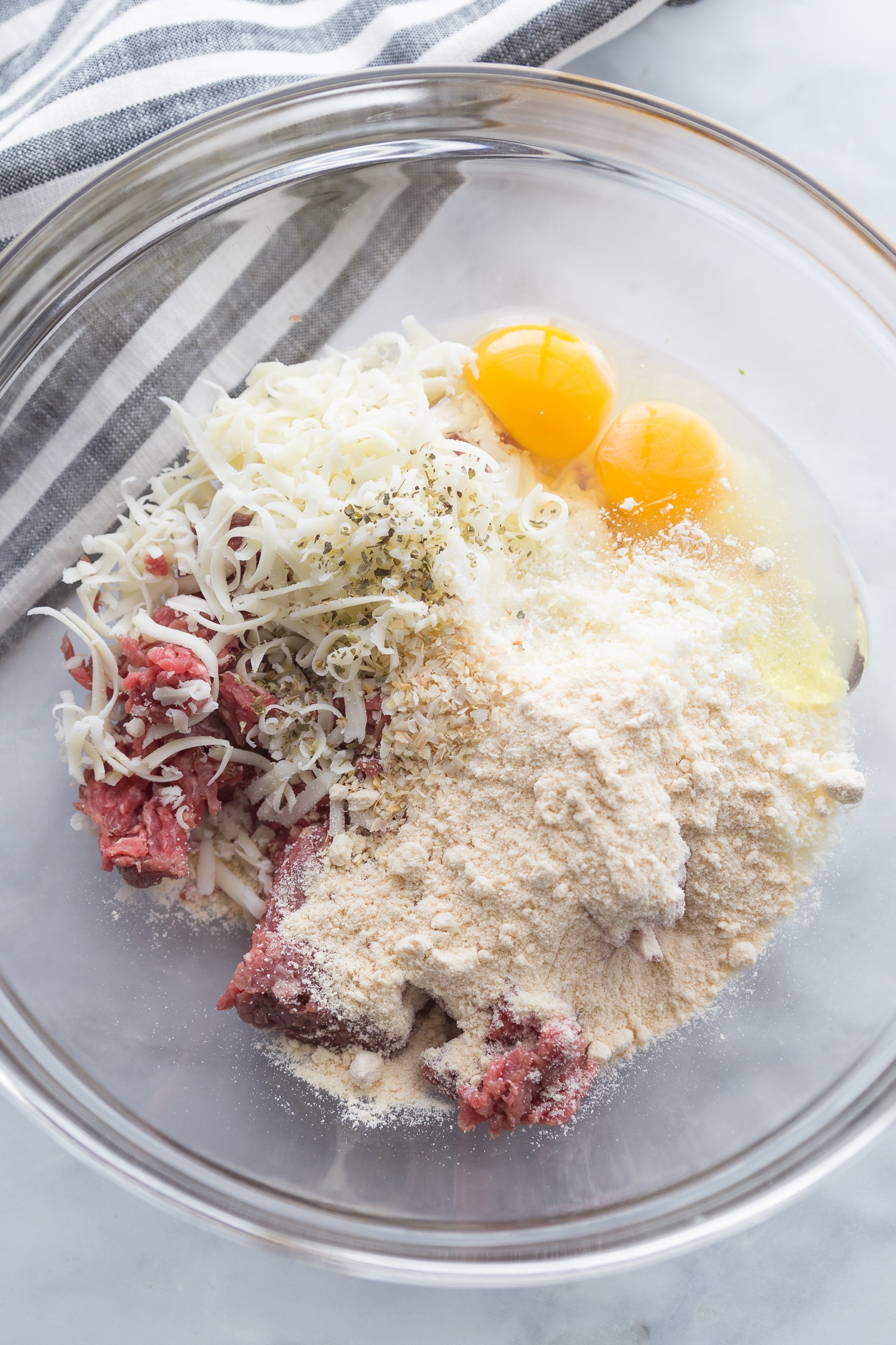 ground beef, cheese, coconut flour, and 2 eggs in a large glass bowl 