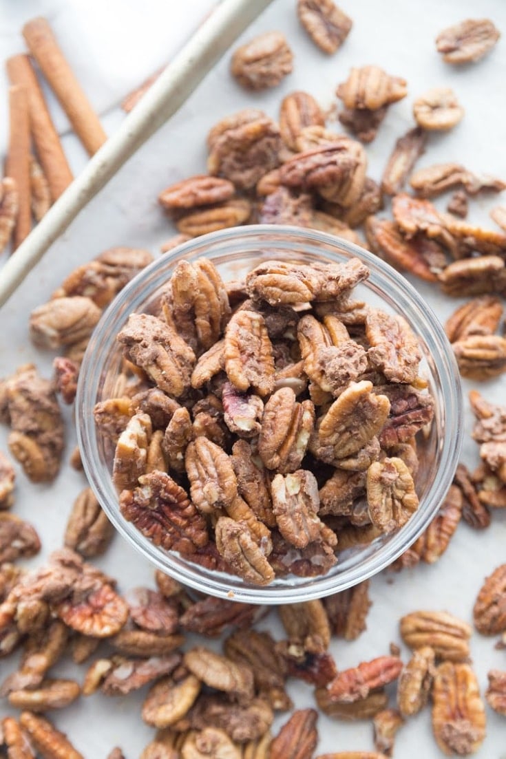 Cinnamon keto candied pecans on a baking sheet and in a jar