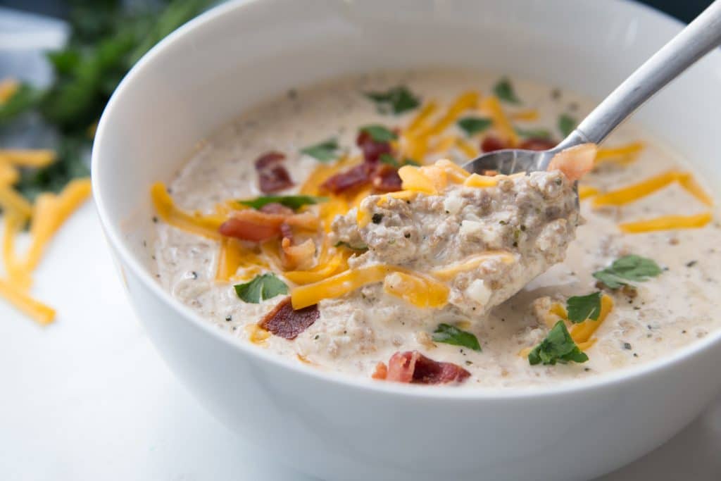 Spoonful of keto cheeseburger soup with bacon on top