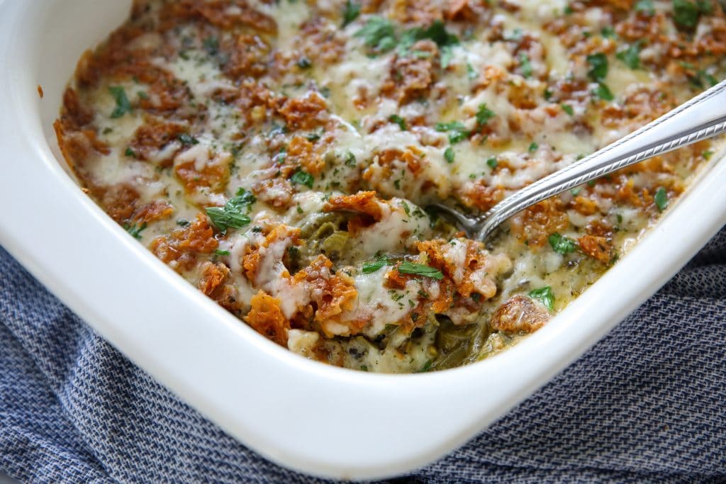 low carb green bean casserole out of the oven in a casserole dish with a spoon in it