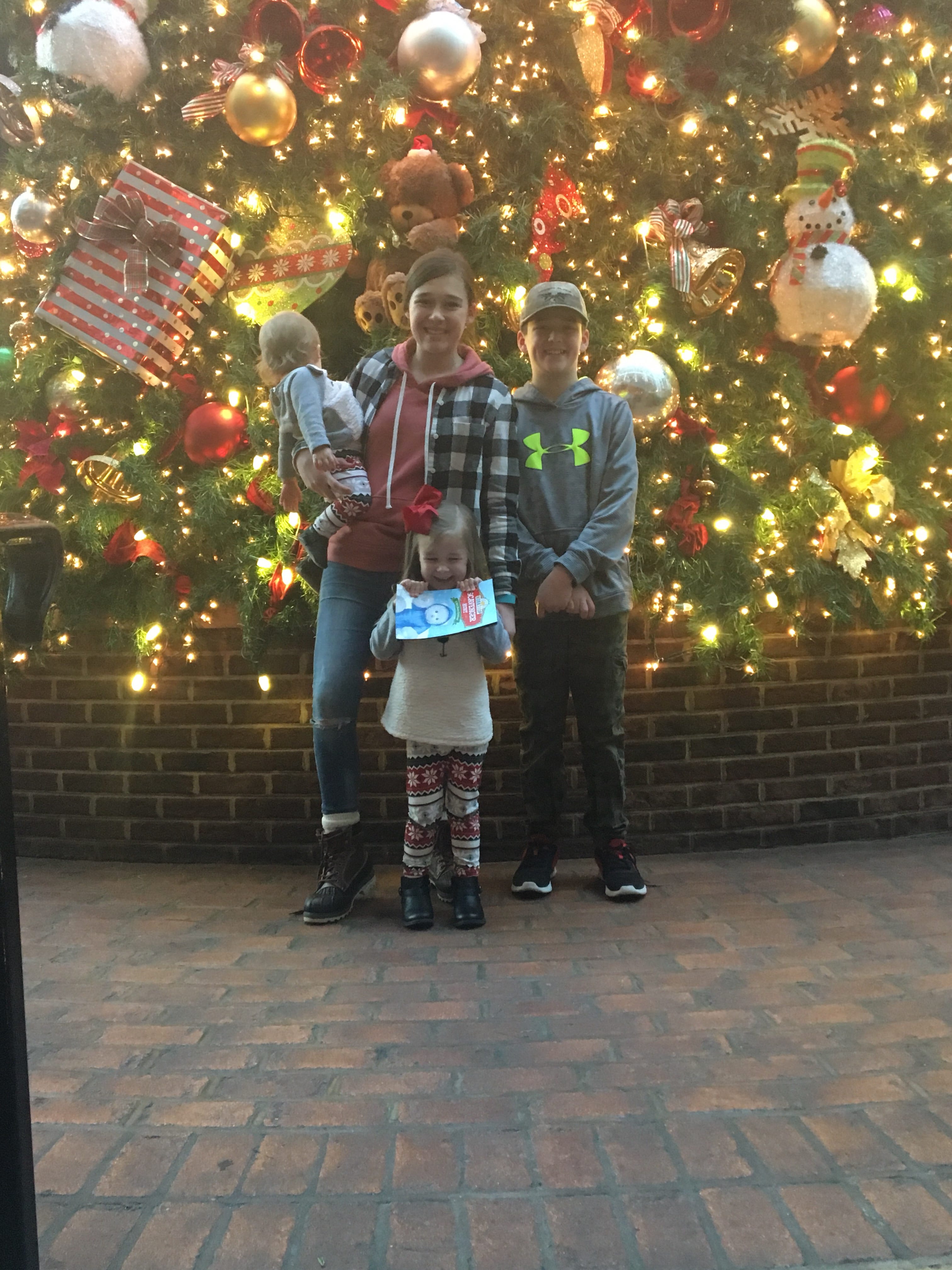 kids in front of huge Christmas tree 
