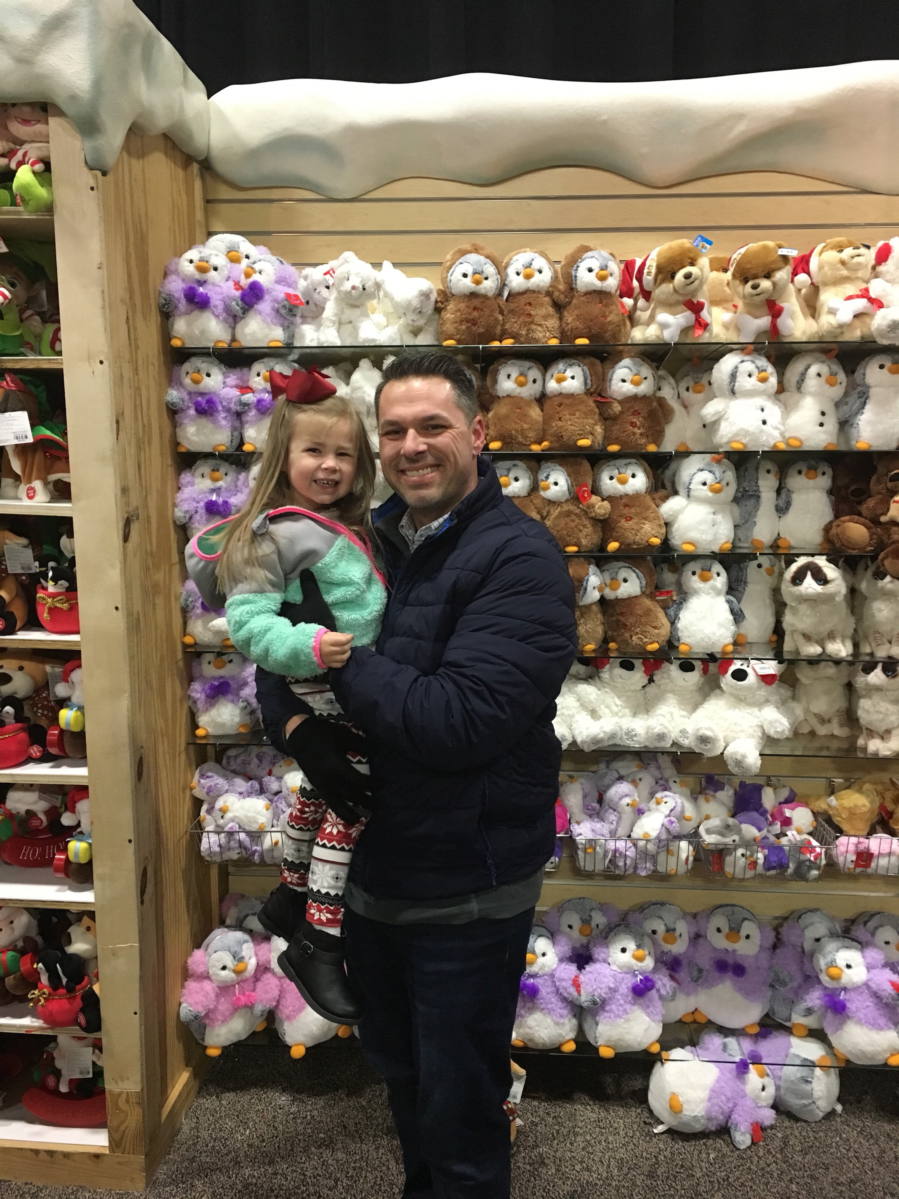 dad & daughter in front of stuffed animals