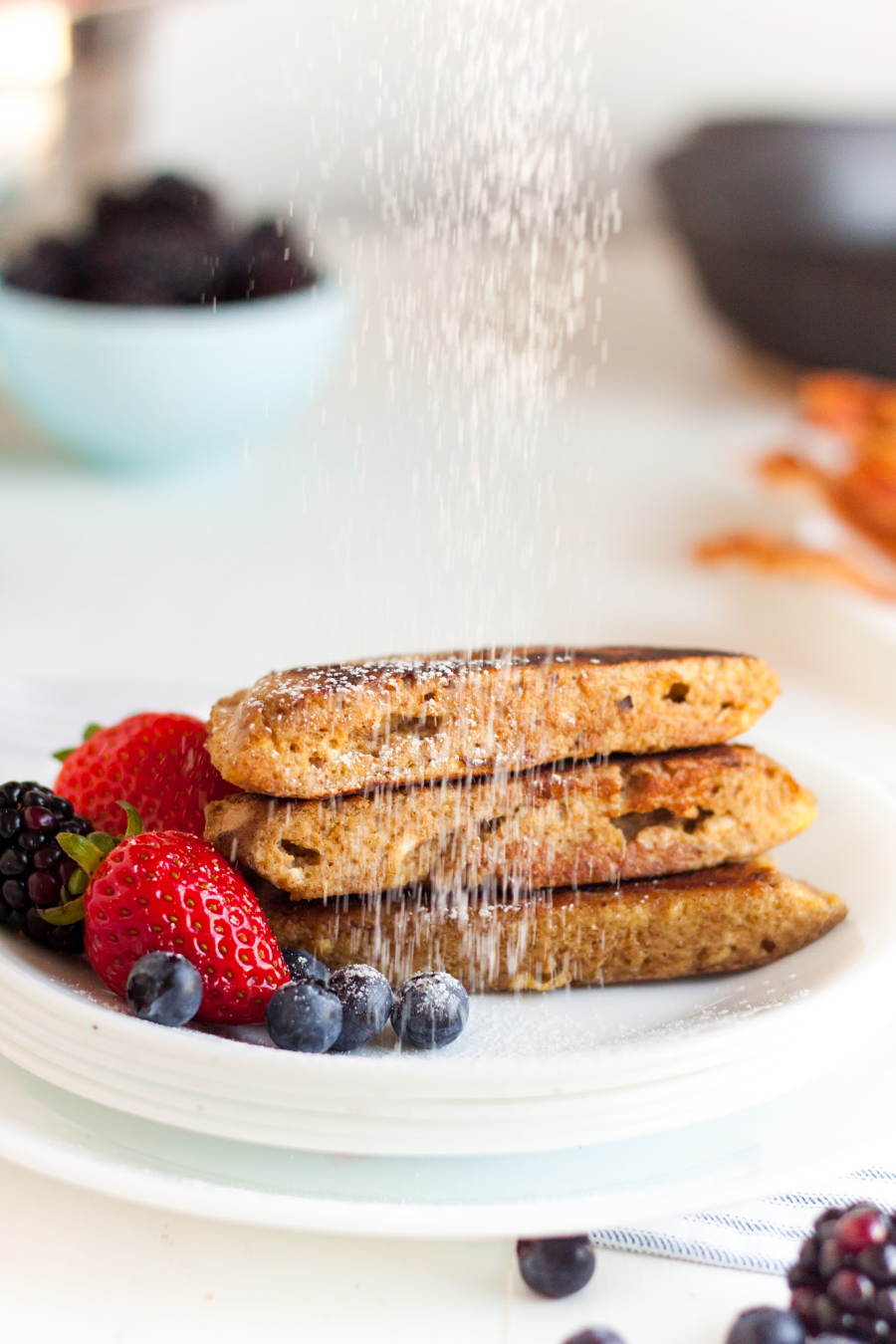 A stack of french toast with berries off to the side.