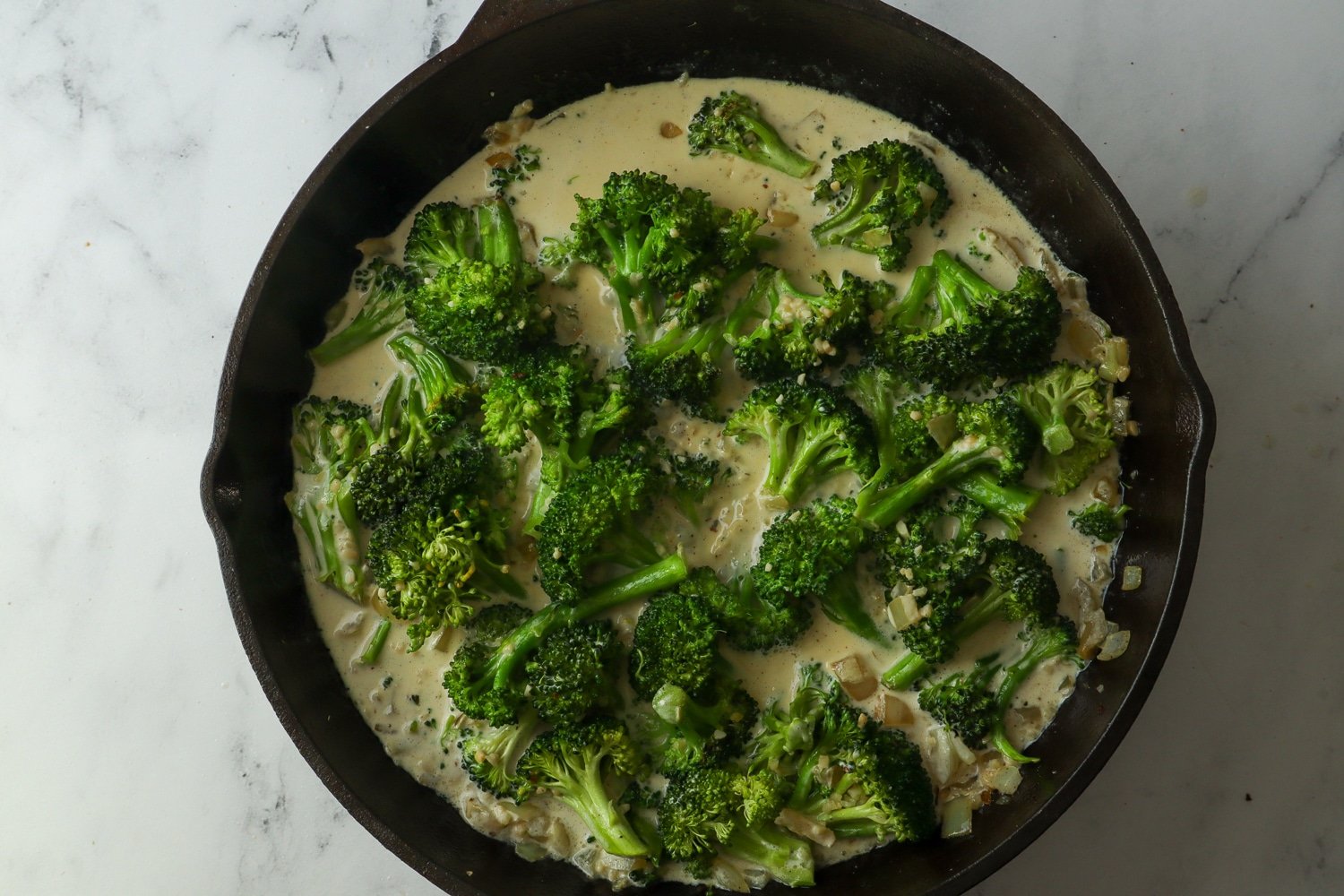 broccoli in cheese sauce in cast iron skillet