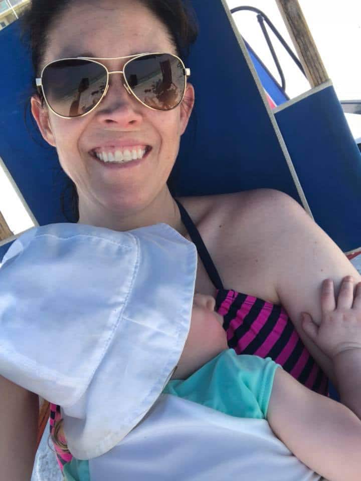 mom holding sleeping baby in a beach chair