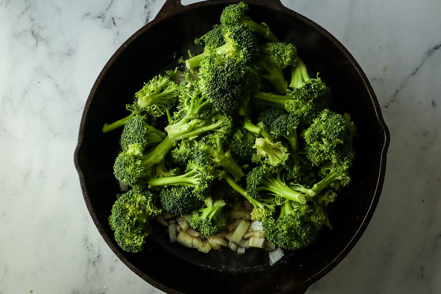 steamed broccoli in a cast iron skillet