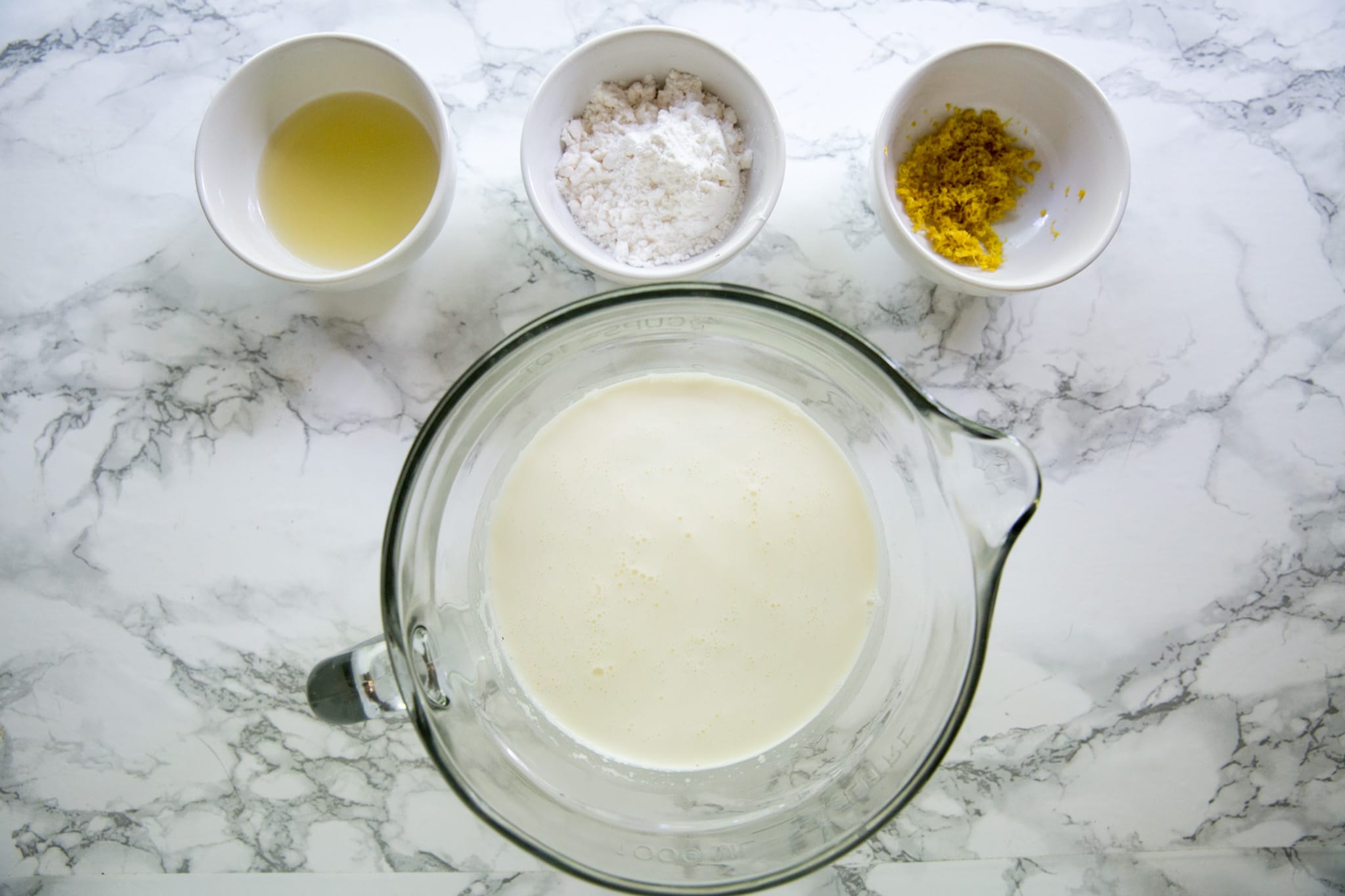 Ingredients for lemon fat bombs sits on a marble top table