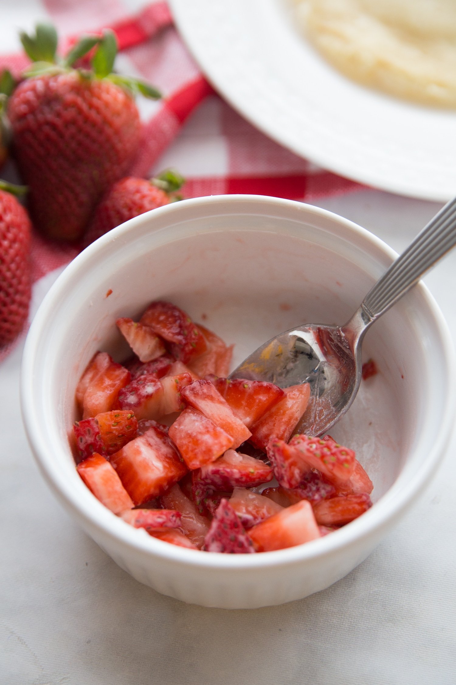 sliced strawberries in a white bowl with keto sweetener
