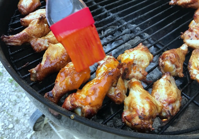 basting low-carb buffalo wings on grill