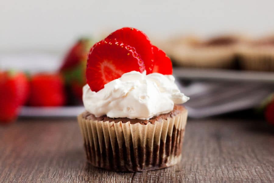 close up image of keto chocolate cheesecake muffin with strawberries on top