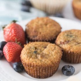 keto berry muffins a white plate with fresh berries