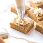 keto pumpkin pie bars with a dollop of cream cheese frosting