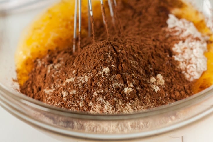 image of keto brownie ingredients being mixed with whisk in glass mixing bowl