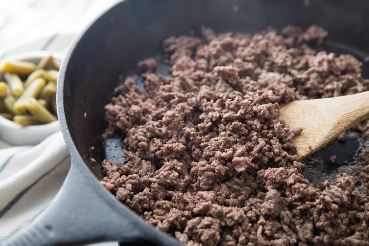 ground beef browning in a cast iron skillet for keto ground beef recipes 