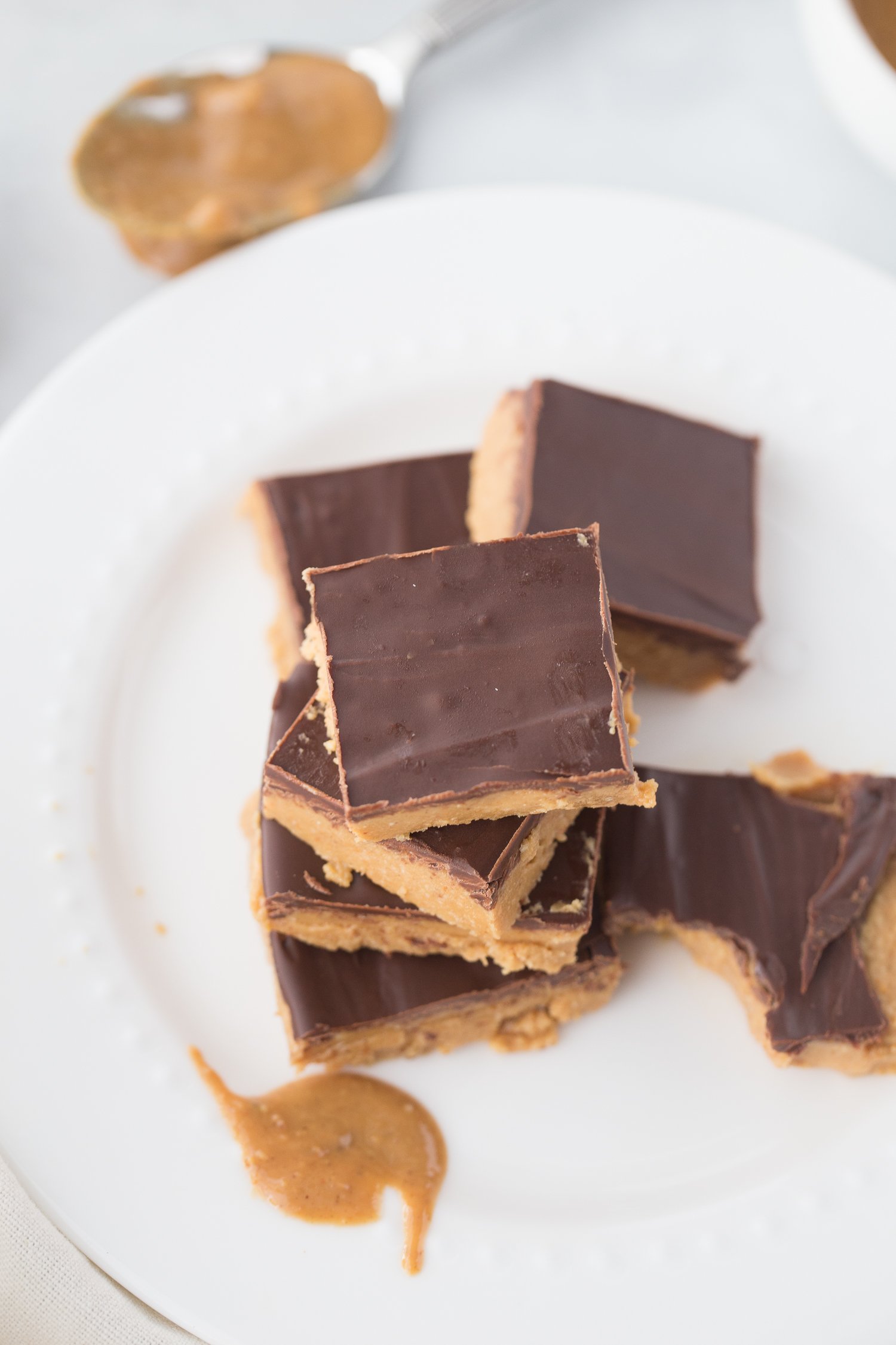 overhead shot of low carb peanut butter bars stacked on a white plate