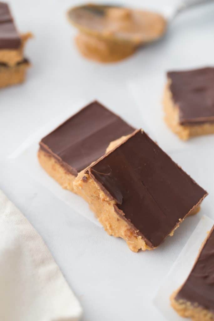 two sugar-free peanut butter bars stacked on parchment paper
