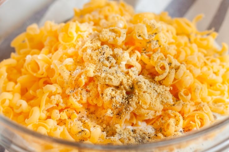 bowl of egg mixture with shredded cheese and seasonings on top for low carb egg bake