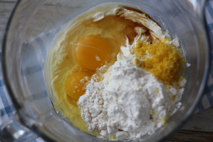 Cream cheese, eggs, Monkfruit, vanilla and lemon zest in glass bowl.