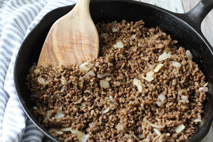 Browned ground beef in cast-iron skillet.