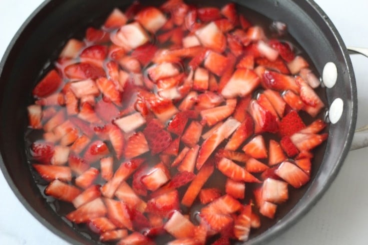 Chopped strawberries, monkfuit, water, and lemon juice in saucepan.