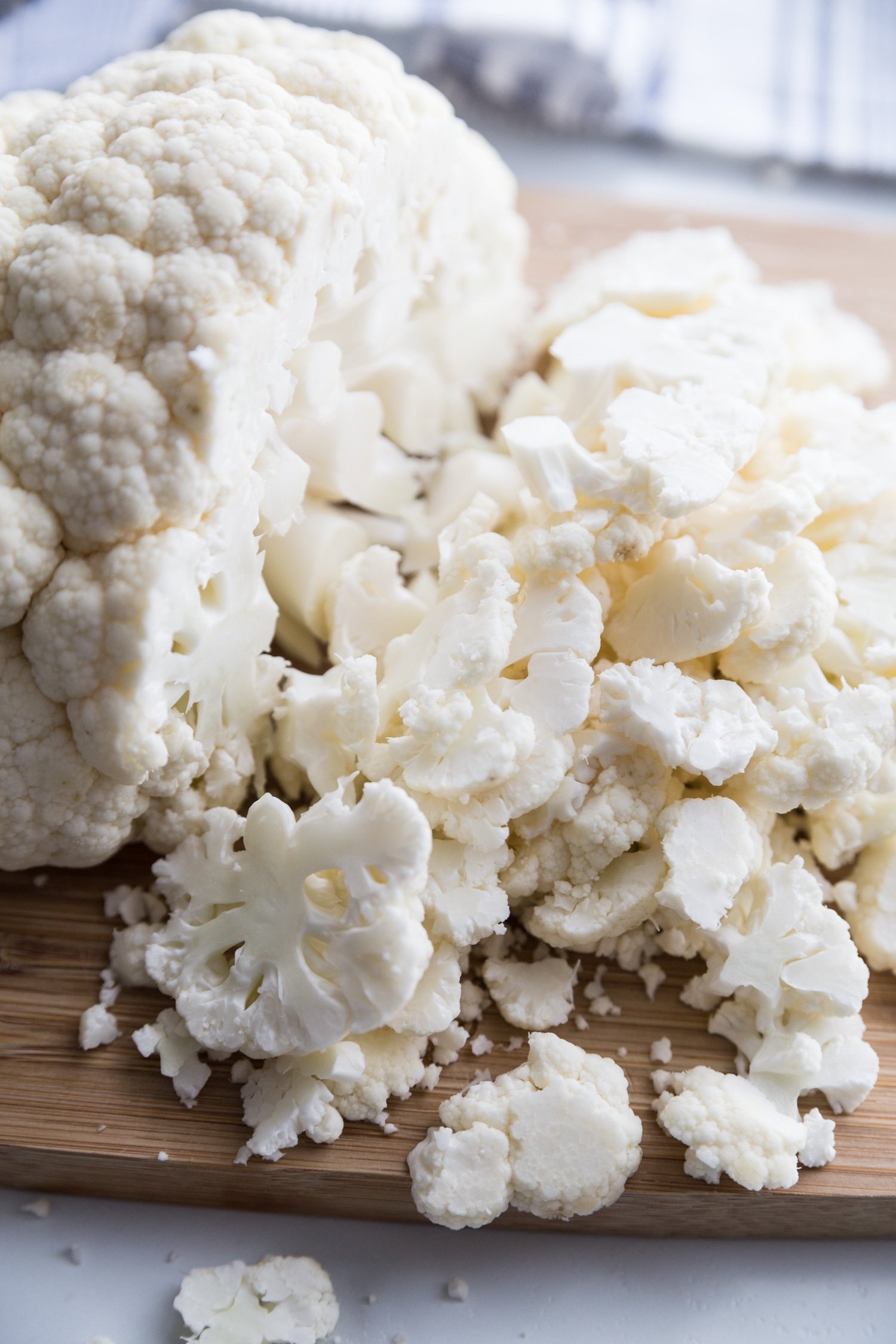 A head of cauliflower being chopped into thin florets.