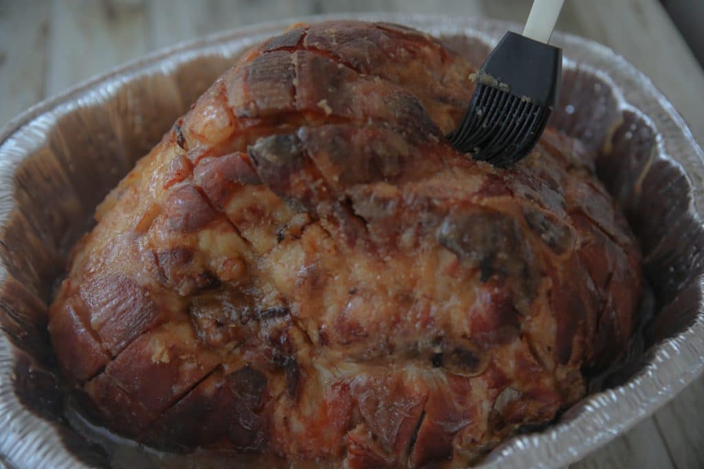 low carb ham out of the oven basting with sugar-free glaze