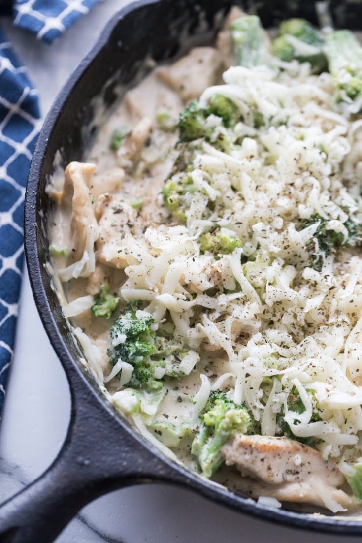 Keto Chicken Alfredo with broccoli with mozzarella cheese shredded on top before baking
