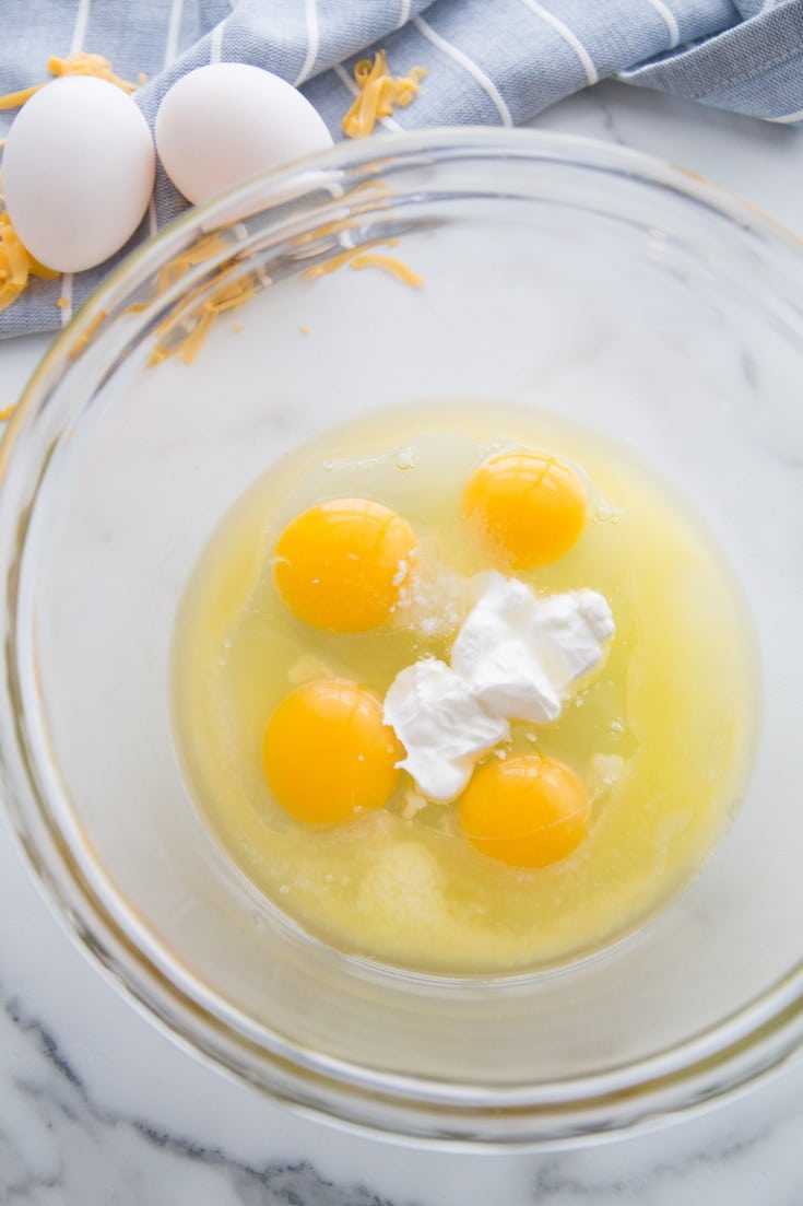 A picture of 4 cracked eggs in a clear dish 