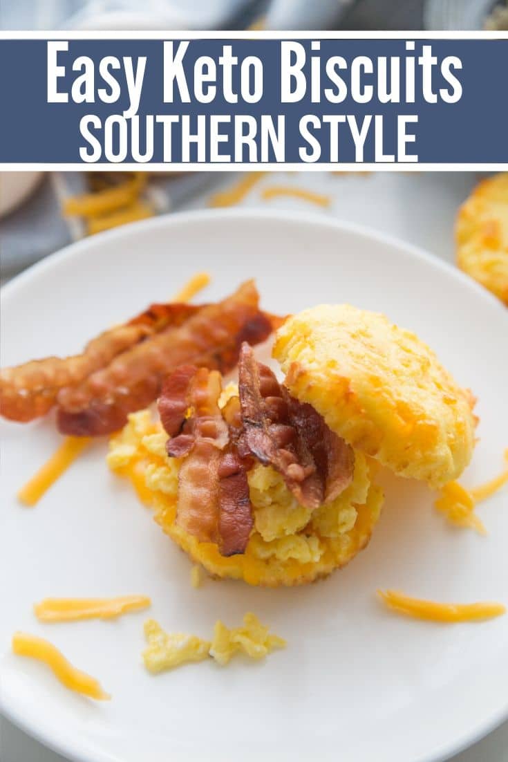 Pinterest friendly image of keto biscuits with bacon and egg on biscuits and slices of bacon on the side.