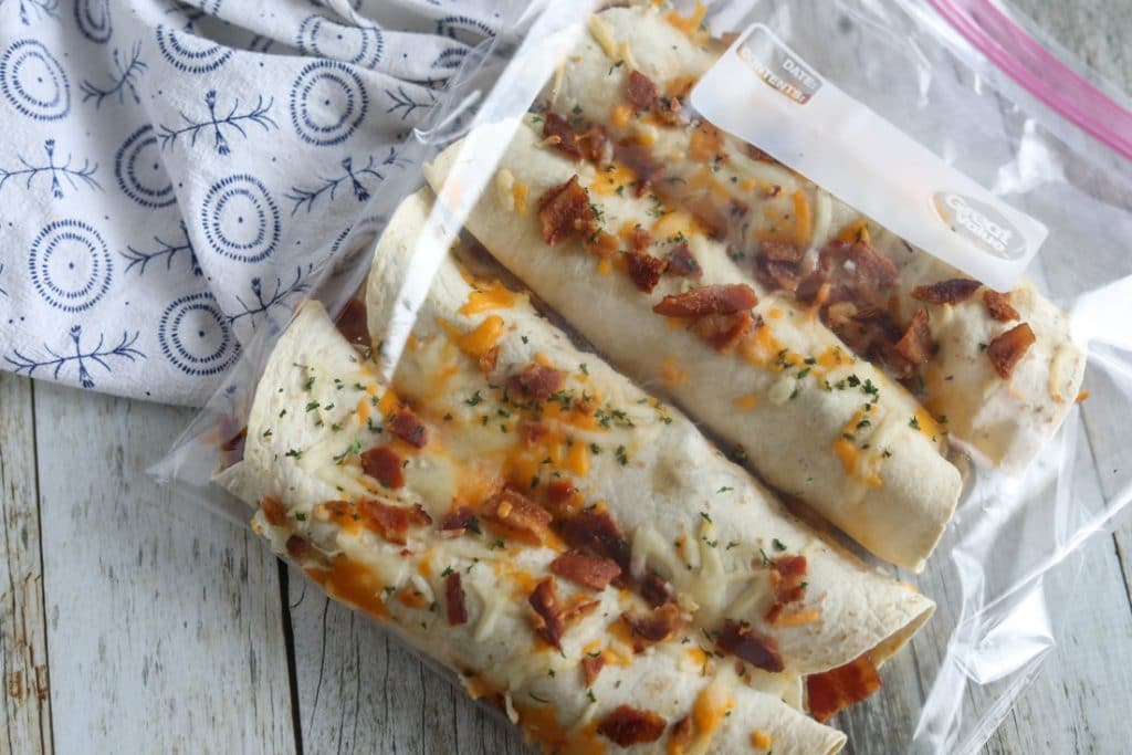 Four cheese, bacon and egg stuffed healthy low carb burritos in a clear freezer bag.