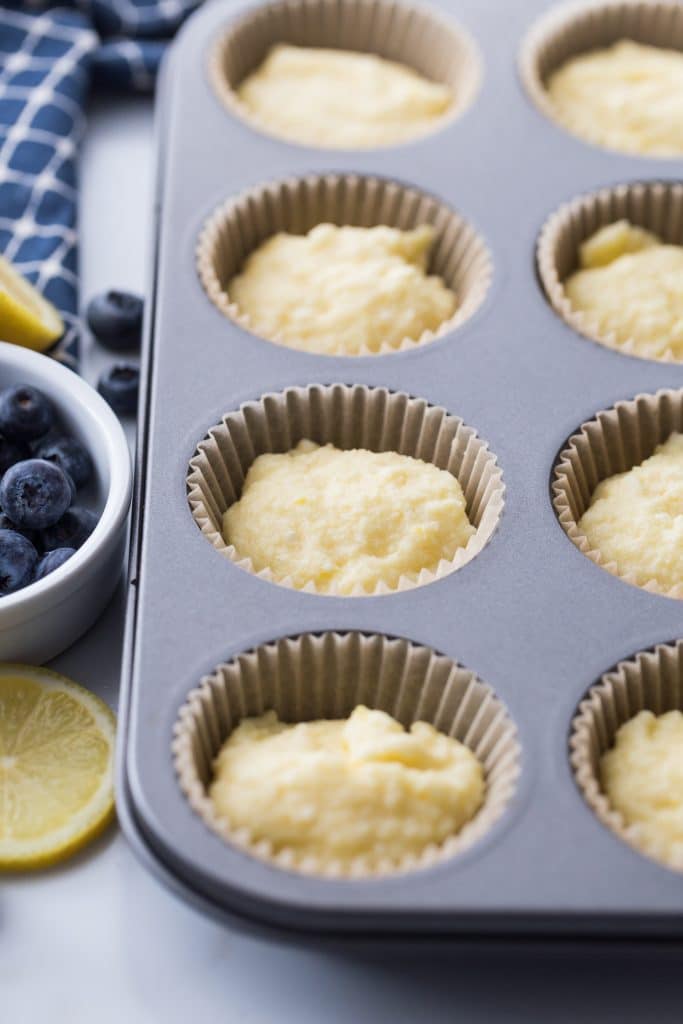 raw blueberry lemon muffin batter in muffin tin with liners