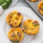 Keto Breakfast Egg Muffins on white plate with a green pepper behind it