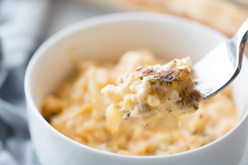 Creamy keto cauliflower mac and cheese in a bowl with a spoonful served