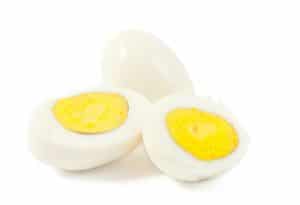 hard boiled egg sliced in half with white background