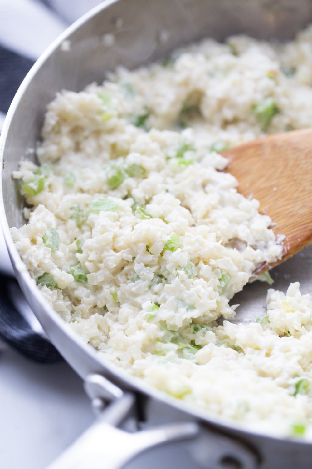 Cream cheese, riced cauliflower, celery sauteed in a skillet.