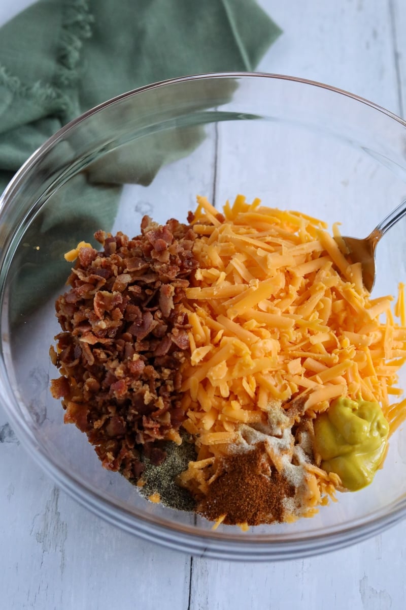 ground beef, cheese, seasoning and bacon in a bowl