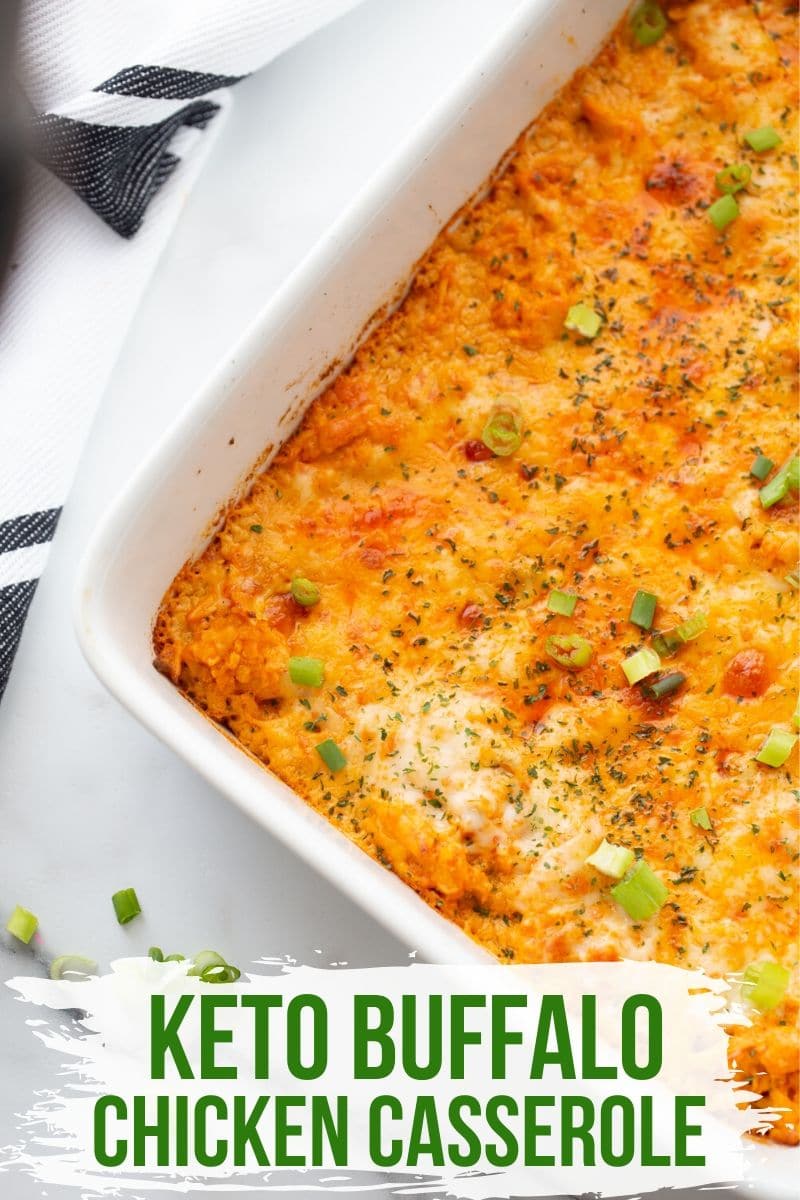 baked buffalo chicken casserole in a white casserole dish with scallions on top.