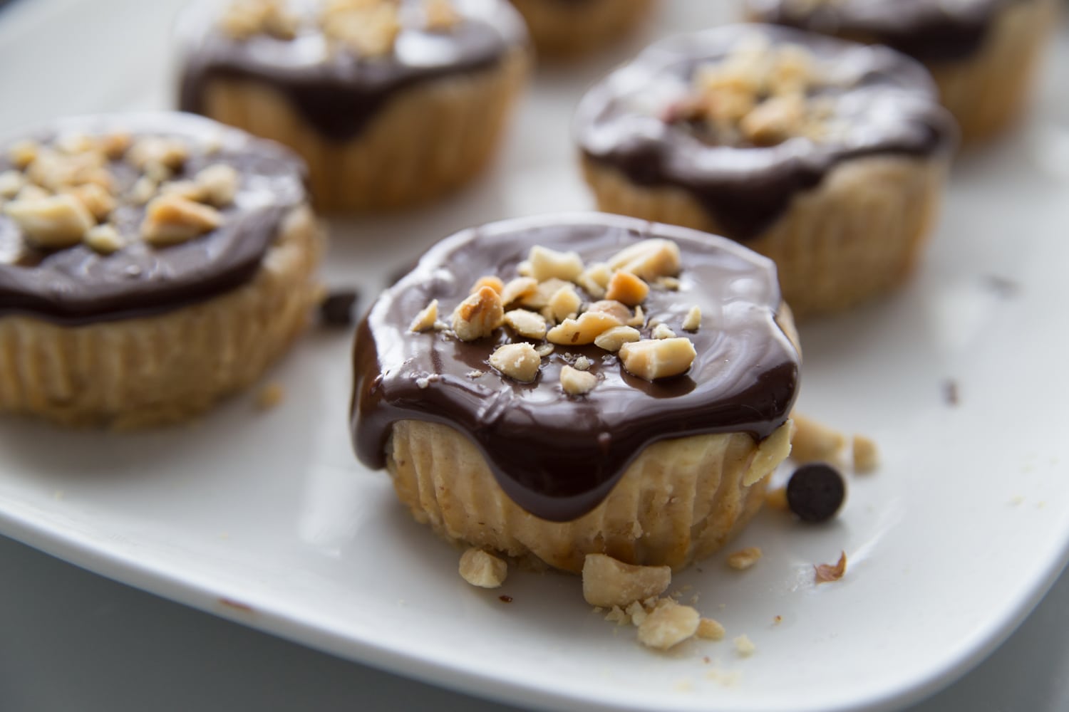 mini cheesecakes with chocolate sauce and peanuts on top
