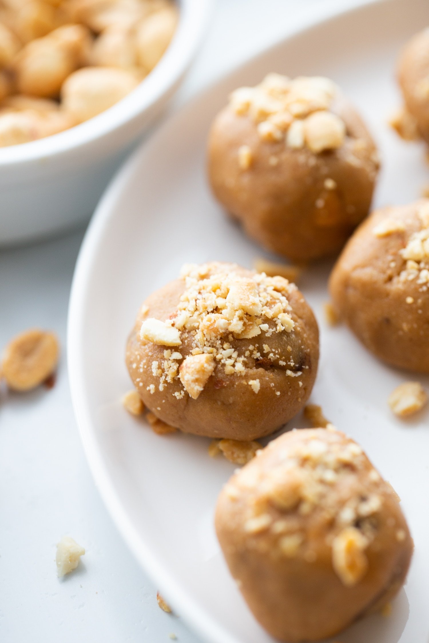 peanut butter fat bombs with crushed peanuts on top and on the side