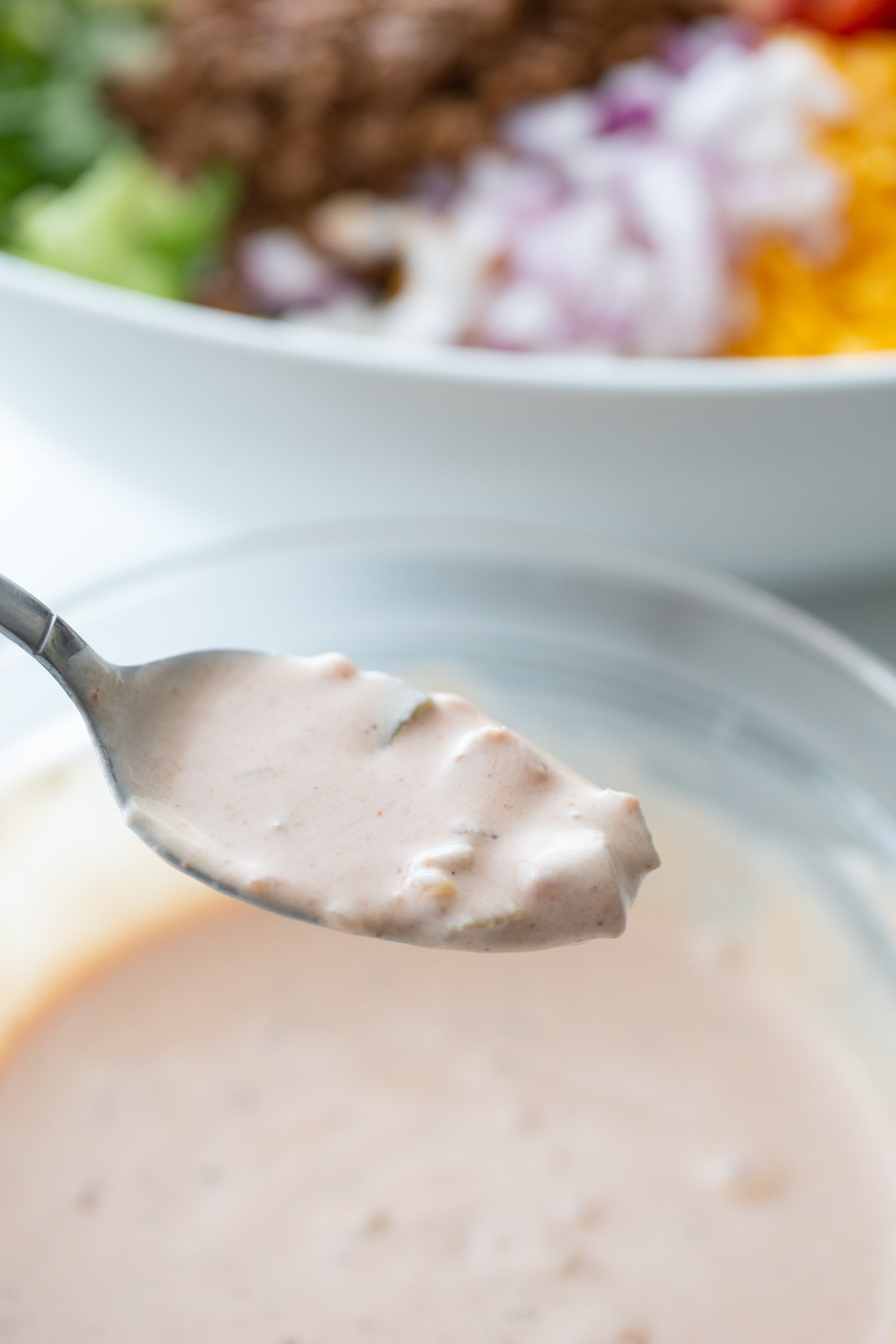 creamy taco dressing with ranch and salsa in a spoon