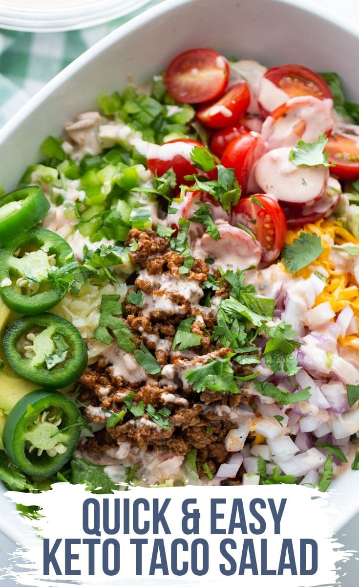 keto taco salad with jalapenos, shredded cheese, tomatoes, ground beef, onions and lettuce in a bowl