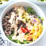 low carb keto big mac salad in a white bowl with sauce on top