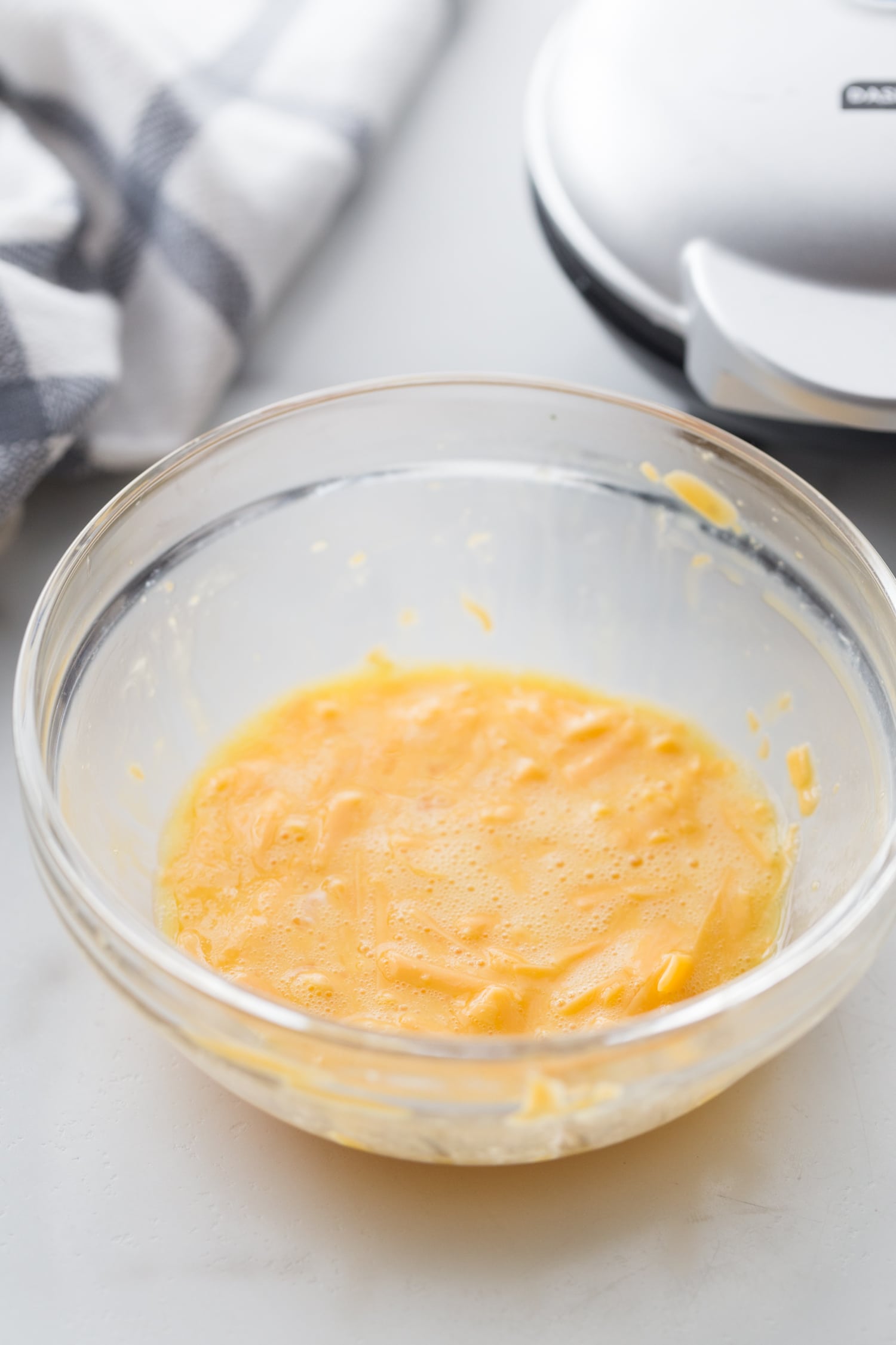 grated cheese and egg combined in a glass bowl