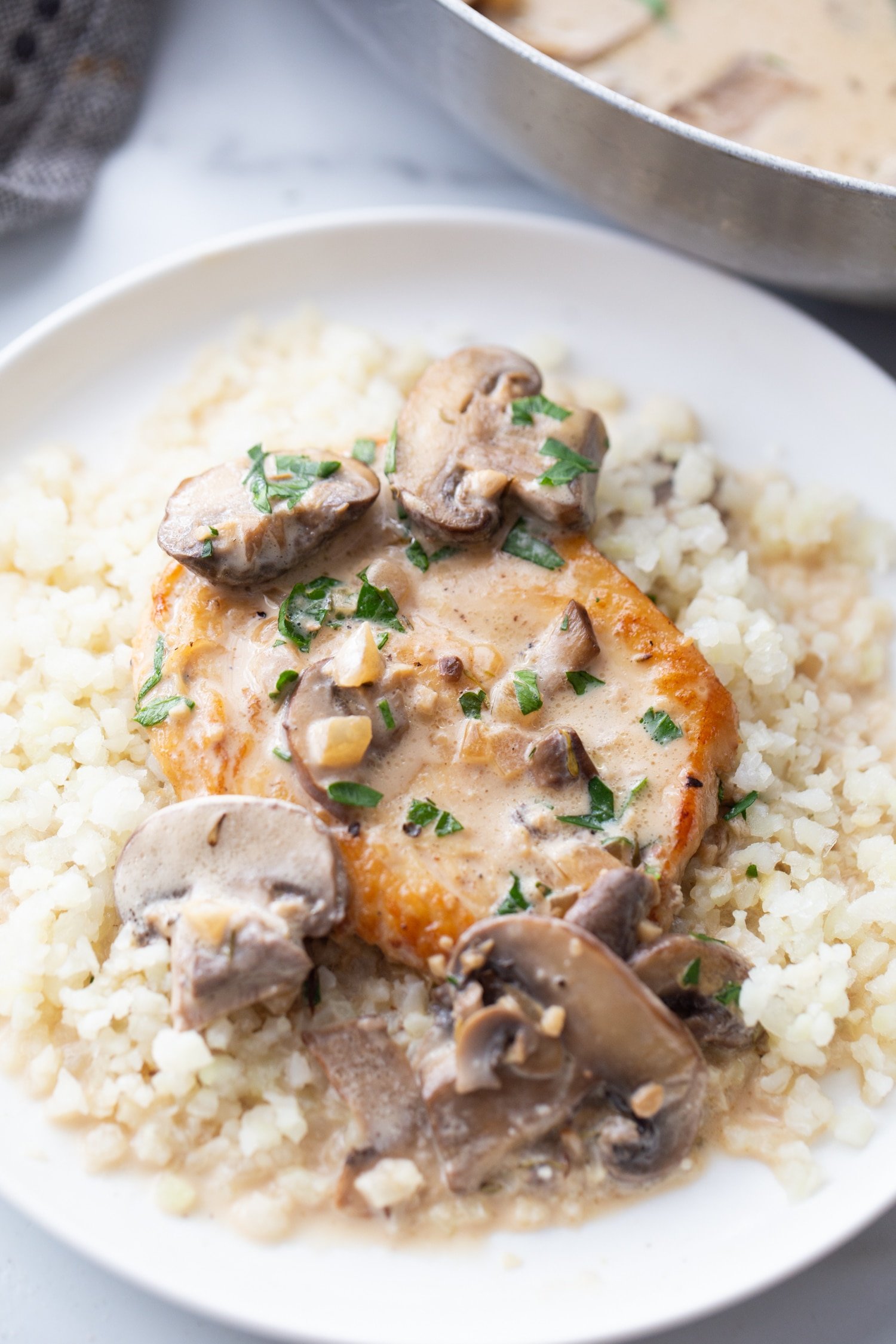 easy chicken marsala over top of cauliflower rice on a plate