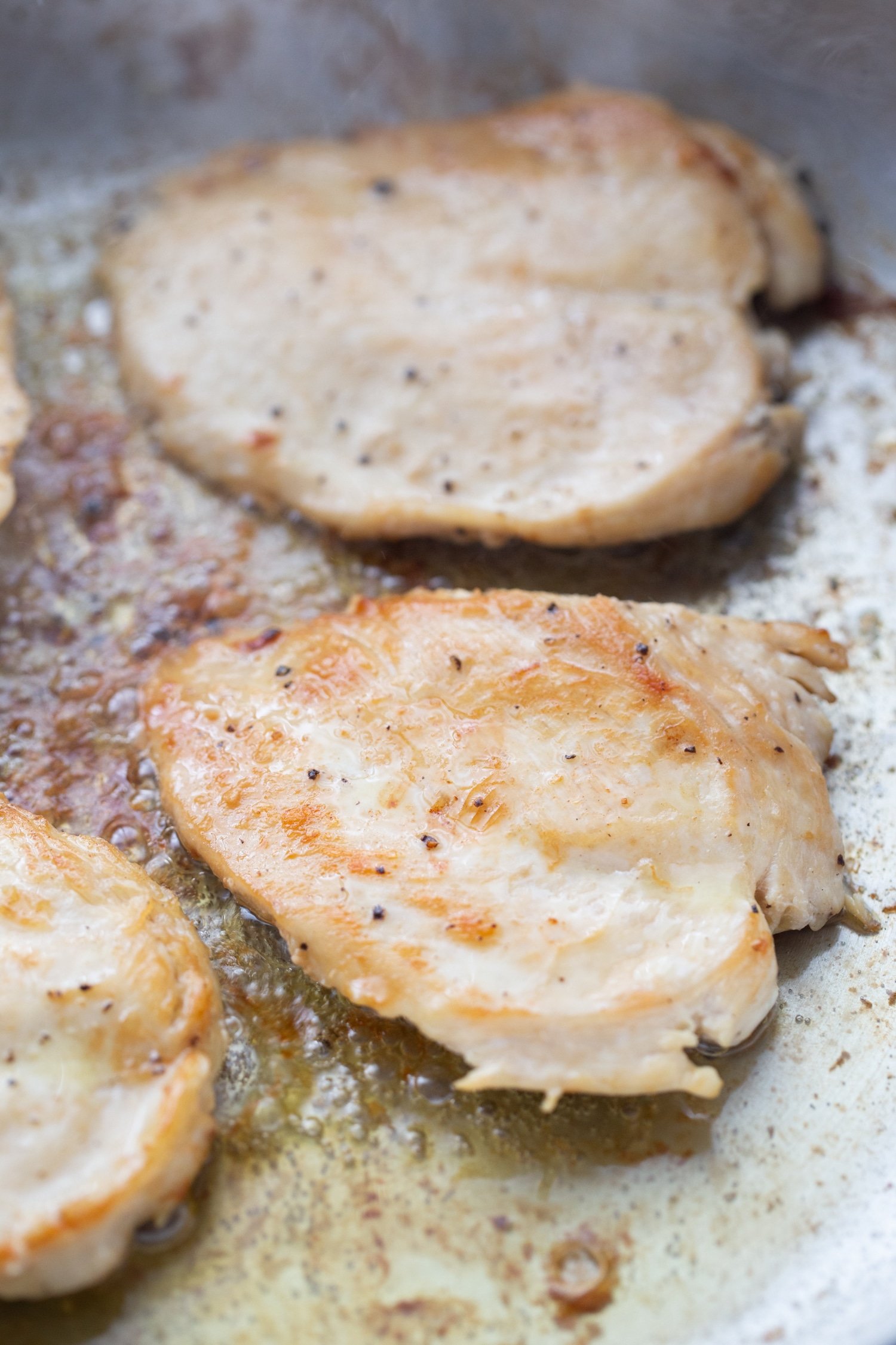 seared chicken cutlets in a pan