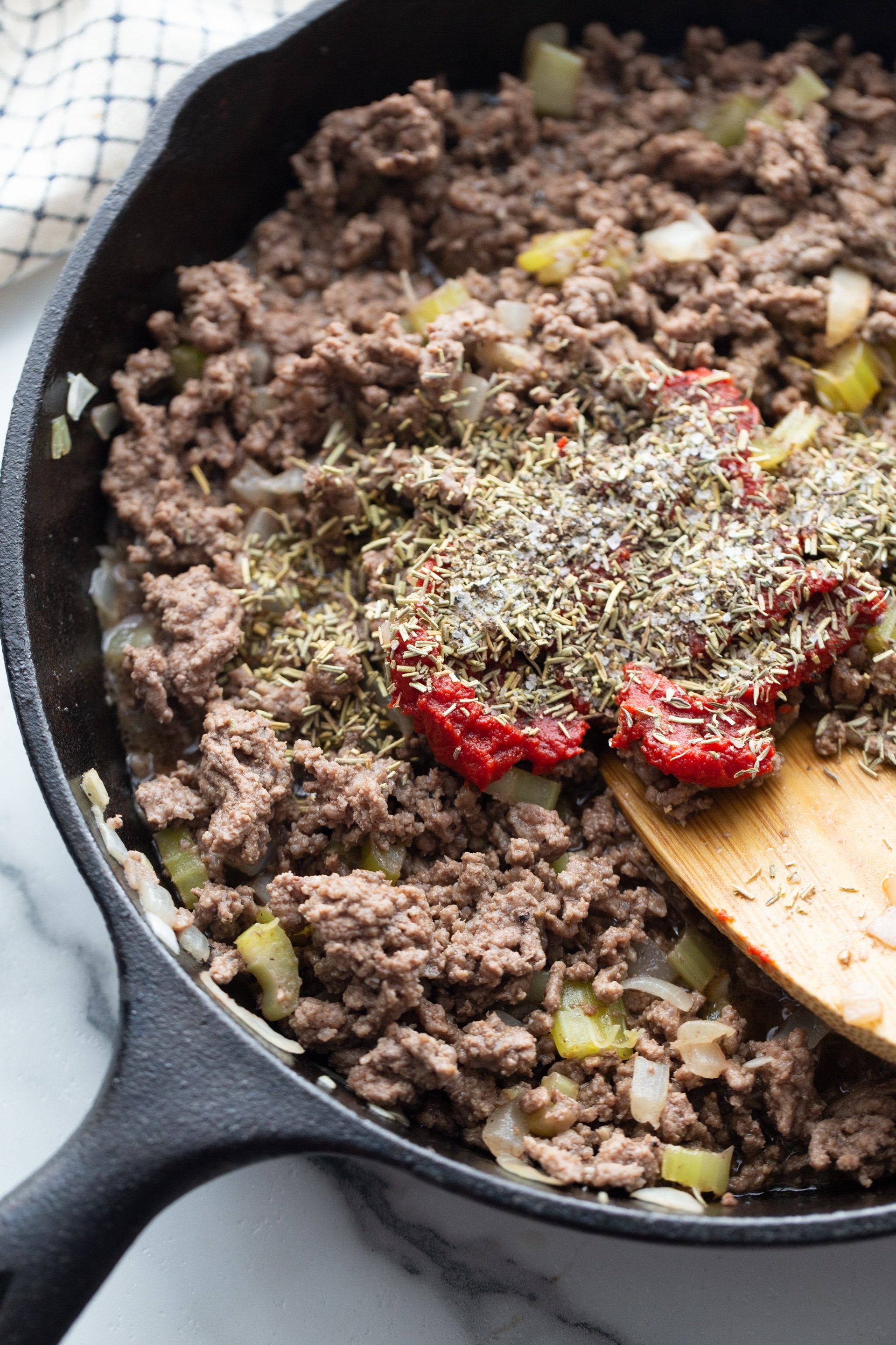 ground beef, rosemary, thyme, peppers and onions in a skillet